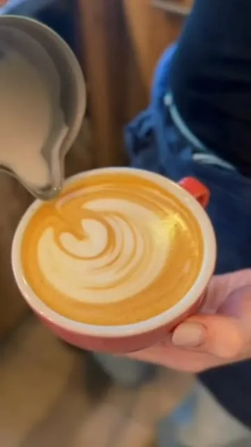 Instagram-Reel: Latte Art – Milchschaum wird in einen Cappuccino in roter Tasse gegossen